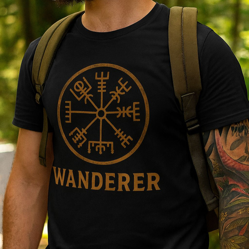 Person wearing a black t-shirt with 'Wanderer' and a compass design, standing outdoors.